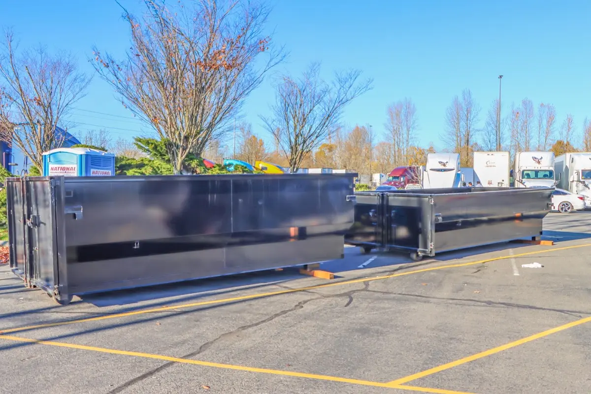 Professional dumpster rental service with roll-off container on residential driveway in Raton